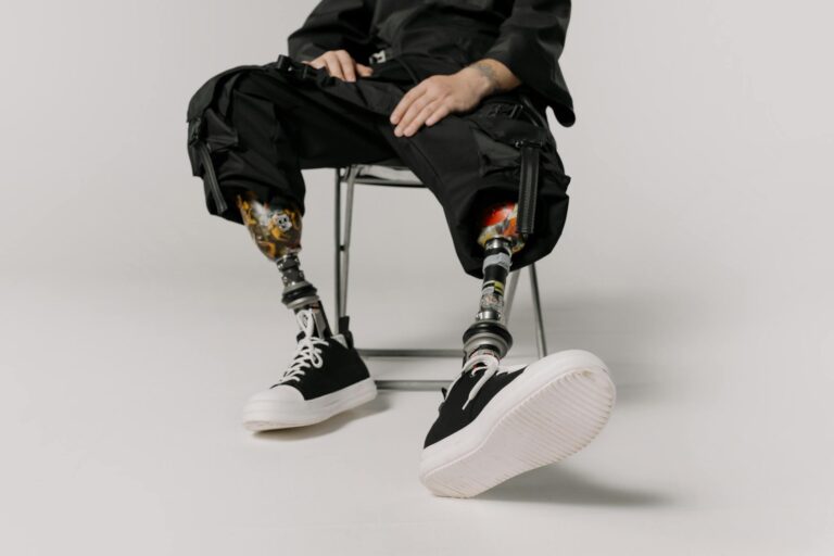 Stylish prosthetic legs with black sneakers captured in a modern studio setting.