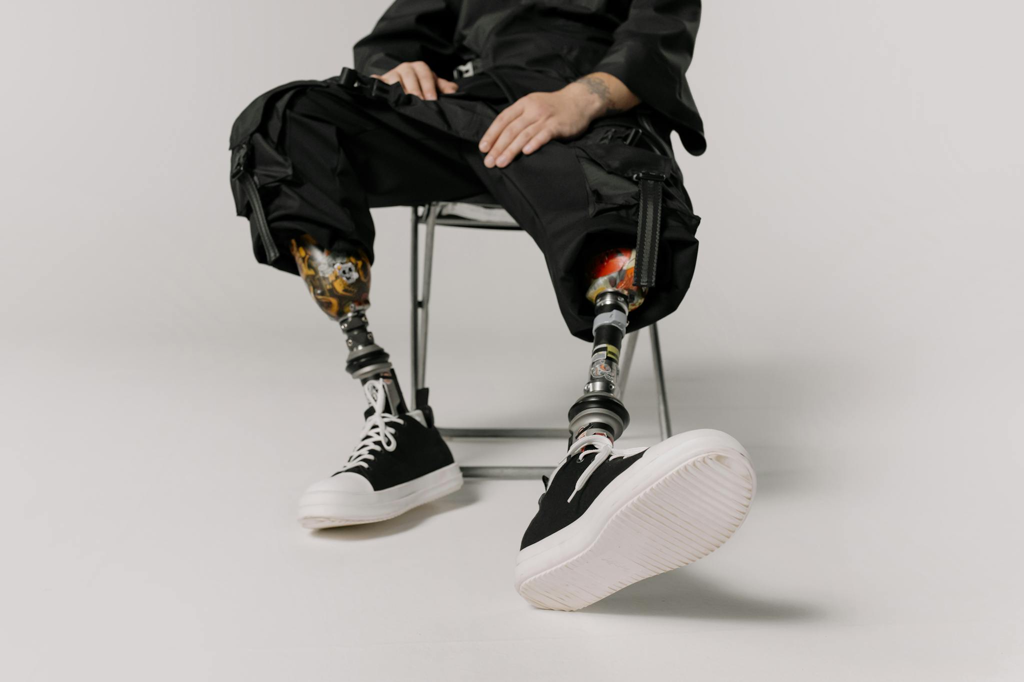 Stylish prosthetic legs with black sneakers captured in a modern studio setting.