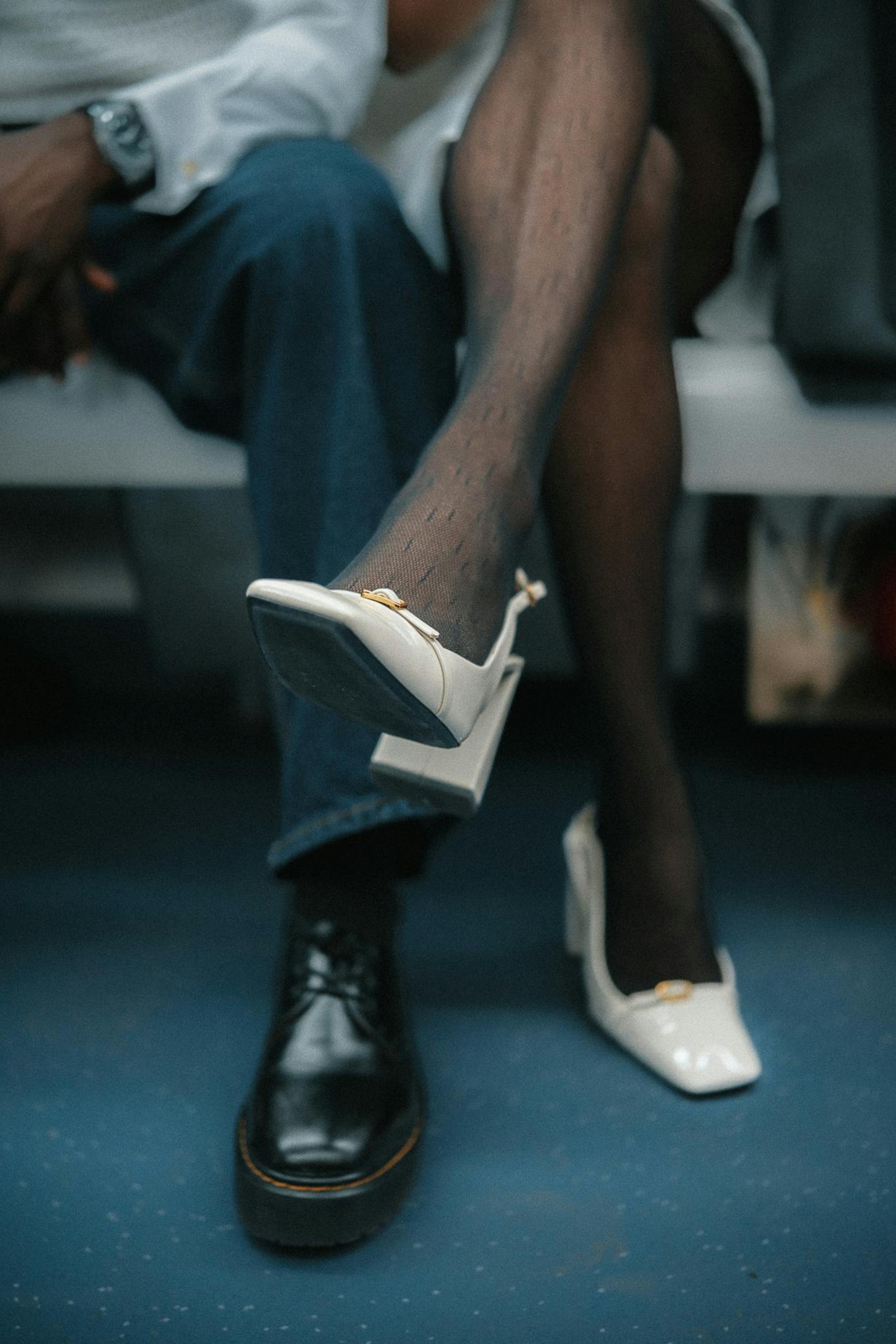 Stylish urban fashion with striking contrast of black shoe and white high heel in an urban setting.